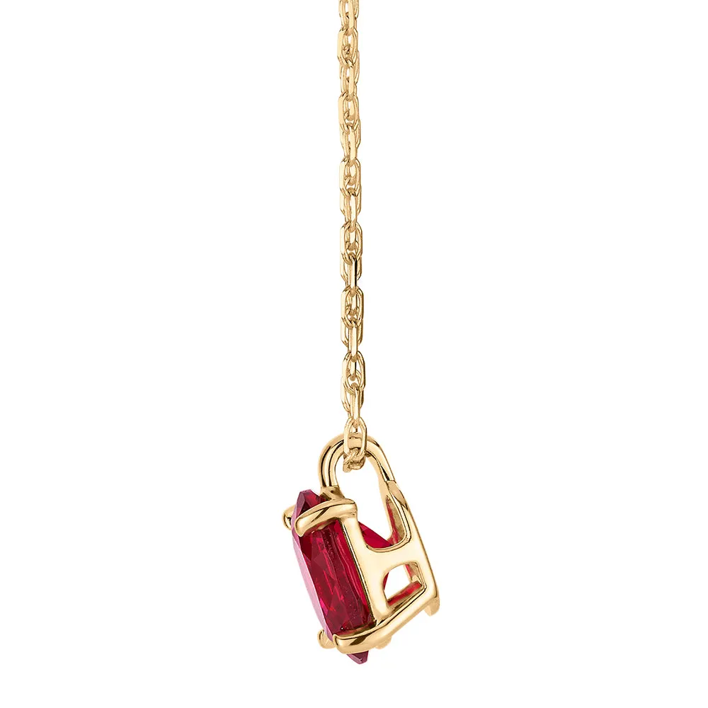 Oval solitaire pendant with ruby simulant in 10 carat yellow gold